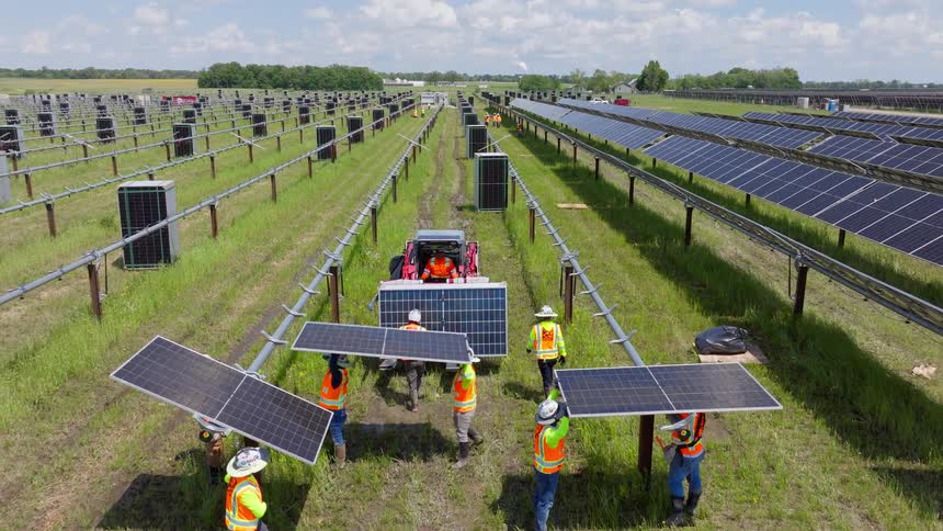 Workers installing solar panels at an outdoor photovoltaic power plant