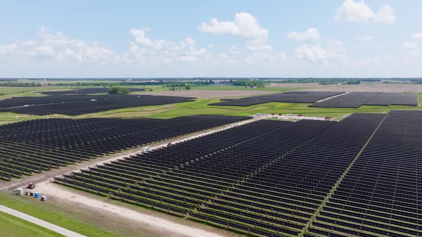 Largescale solar farm displays gridaligned panels over open field under clear sky