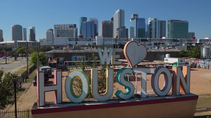 Sign in the foreground with downtown houston buildings in the background