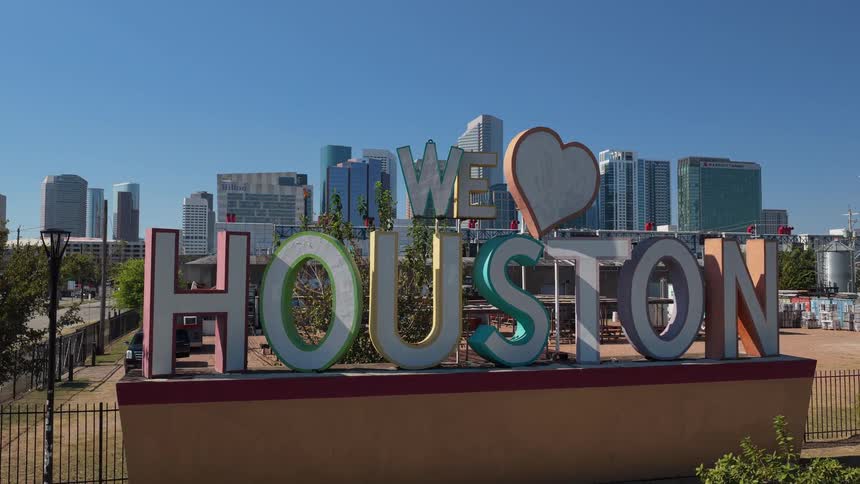 Houston sign outside of the city with towers and skyscrapers in the distance