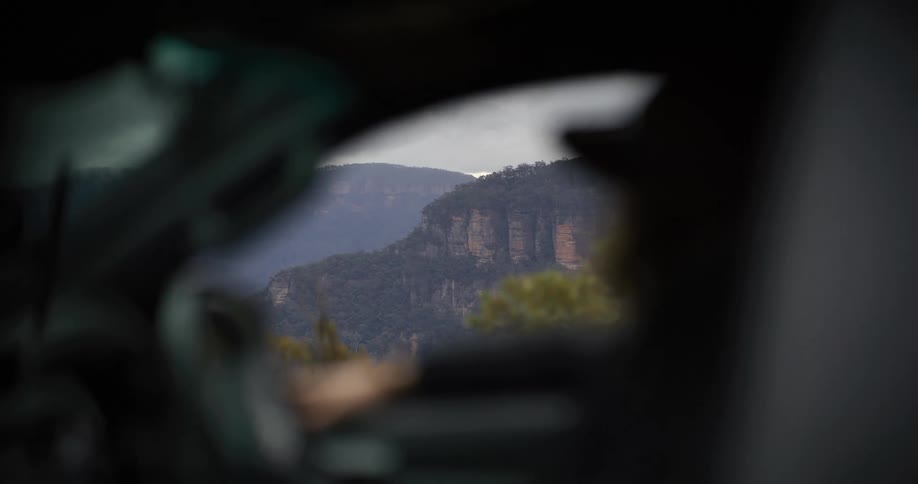 Mountains in the background framed through the blurred interior of a vehicle