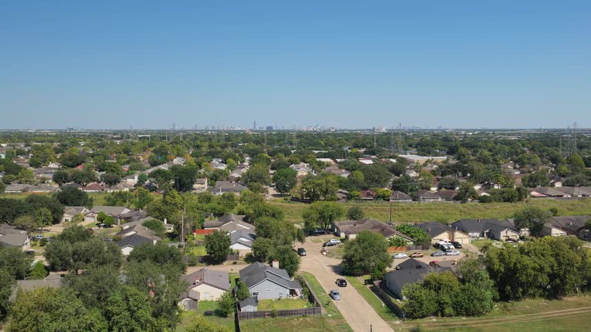 Treelined residential neighborhood with singlestory houses near the urban skyline
