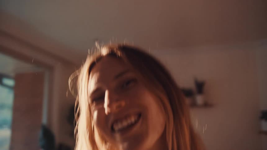 The woman is smiling and dancing