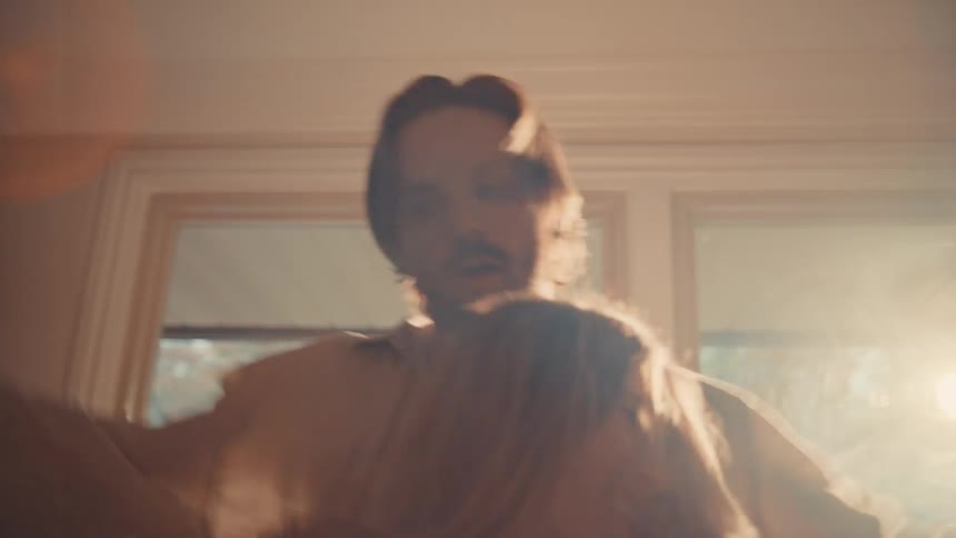 Couple dancing indoors with sunlight streaming through the windows in the background