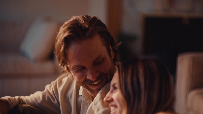A man and woman sitting around laughing