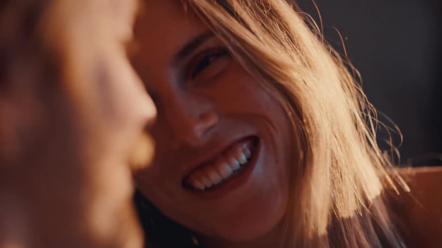 The woman is talking and smiling with a man