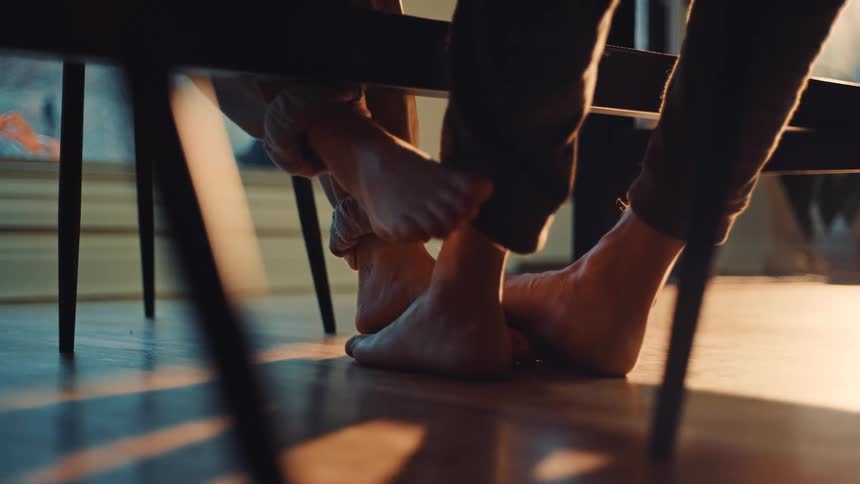 Two people are playing footsies under the table