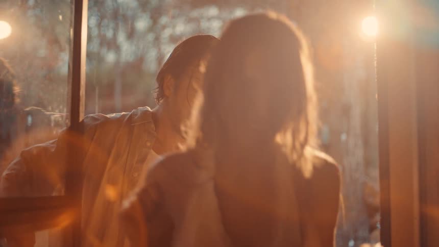 Couple entering through the door with bright sunlight illuminating the scene