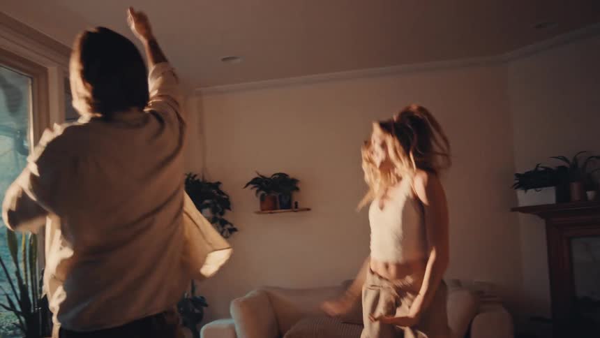 The couple dance together in the living room