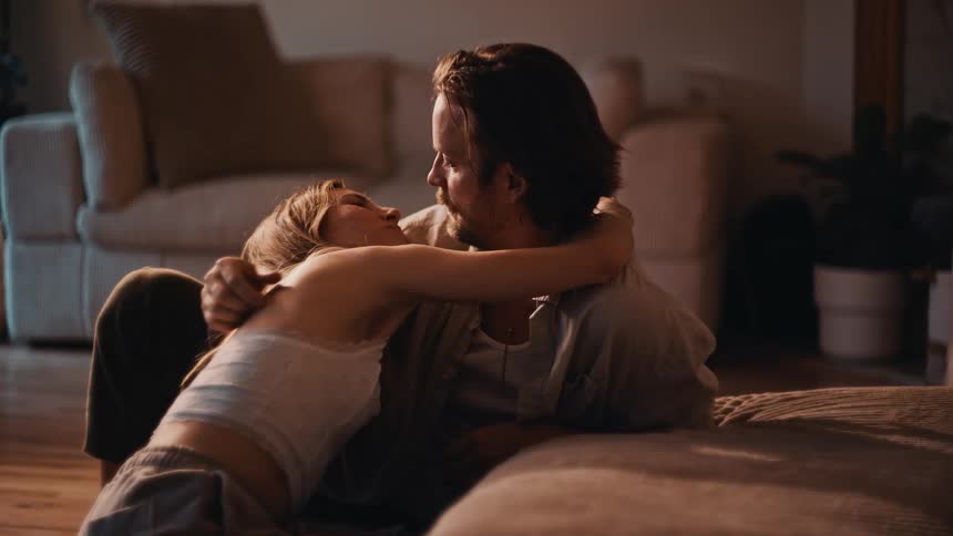 The man and woman talk and hug on the floor