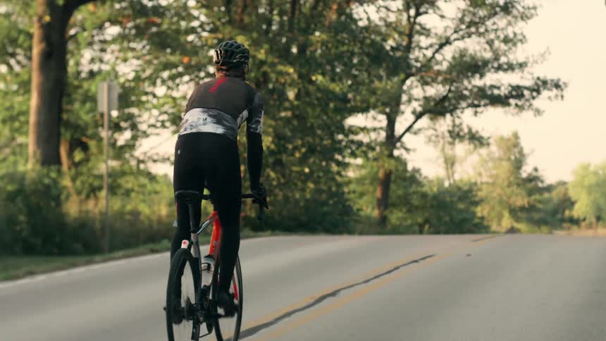 The man is riding his bicycle down the road