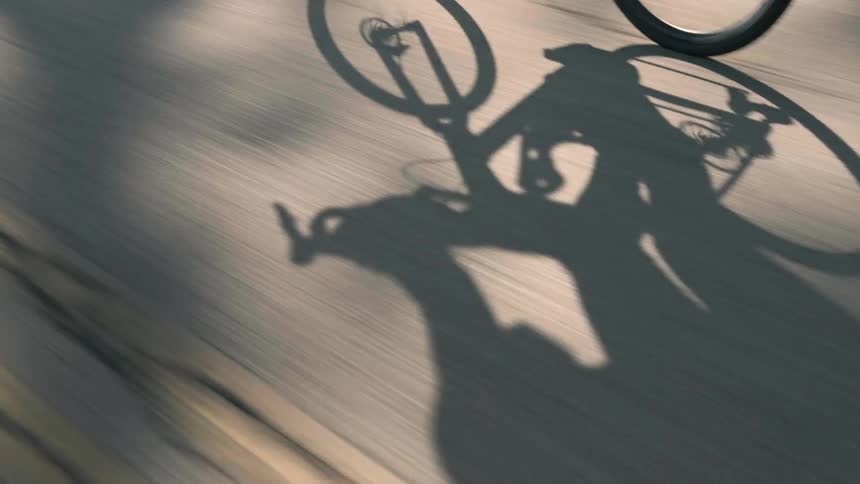 A person cycles on the street on a sunny day