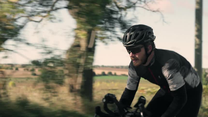 The cyclist pumps his pedals on the road