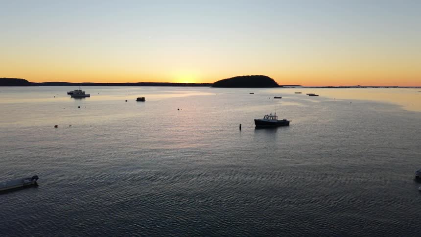 Boats anchored in a bay during sunset