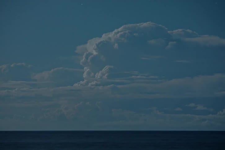Lightning illuminates storm cloud over the ocean