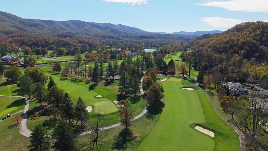 Aerial of a green golf course in a city during daytime