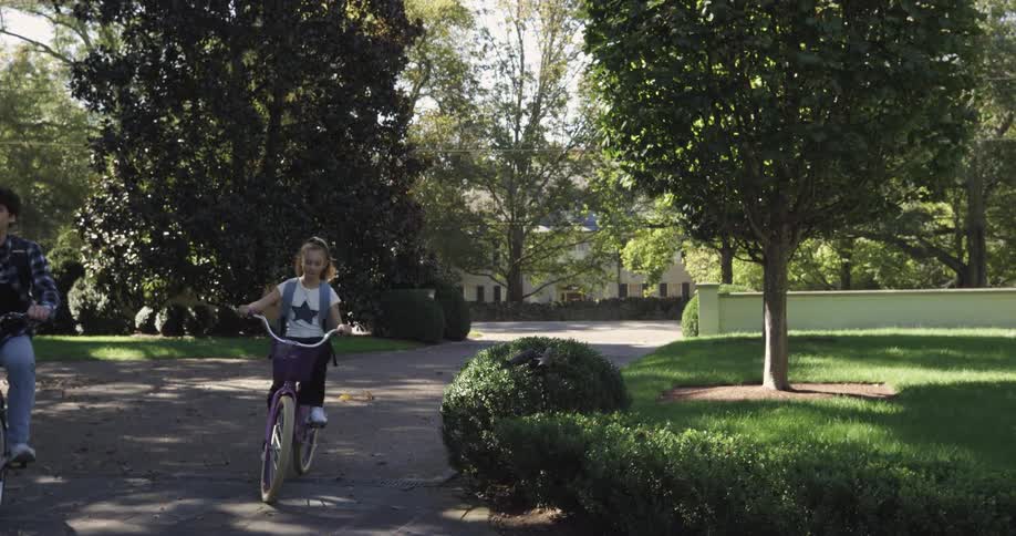 Teenager boy and female child riding bicycles and carrying backpacks on an urban area outdoors during day time