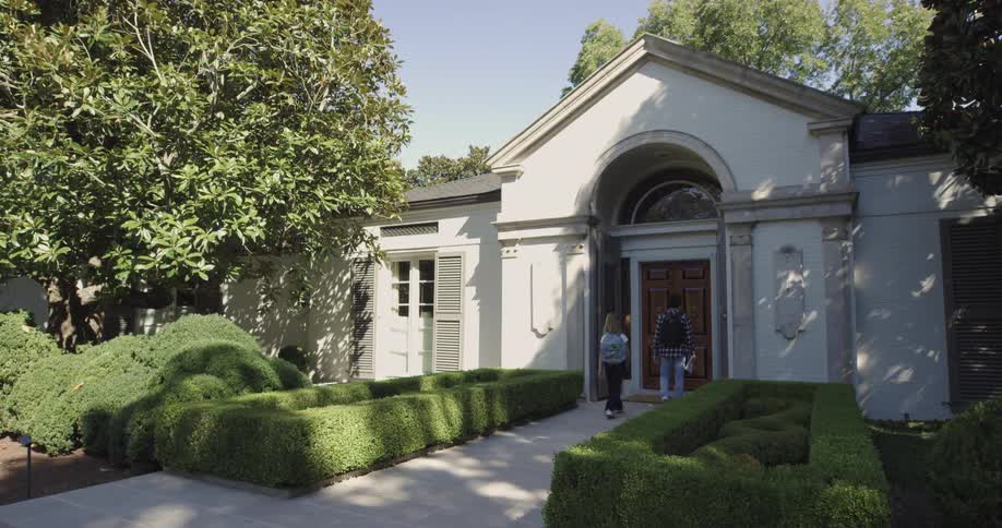 Two students walking towards the door of a house