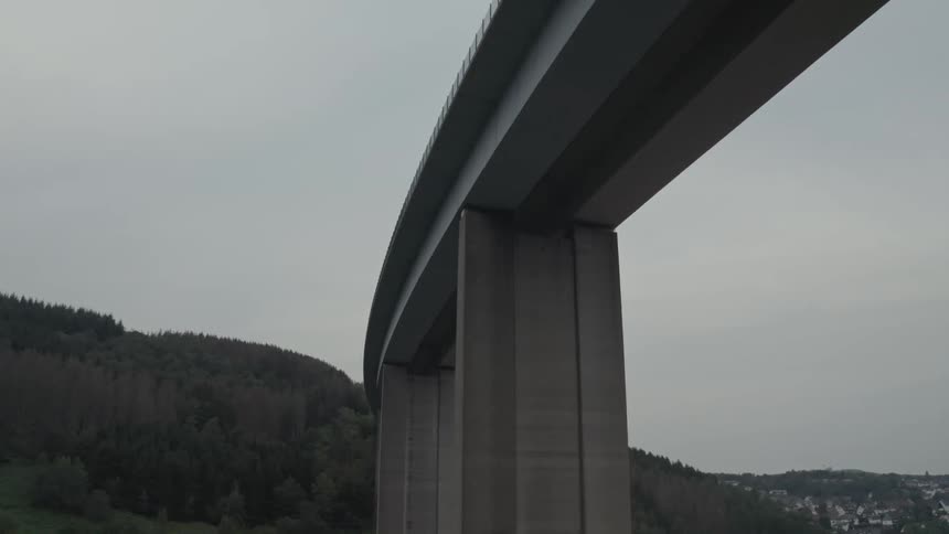 Bridge next to a hill with an urban area on the background outdoors during day time