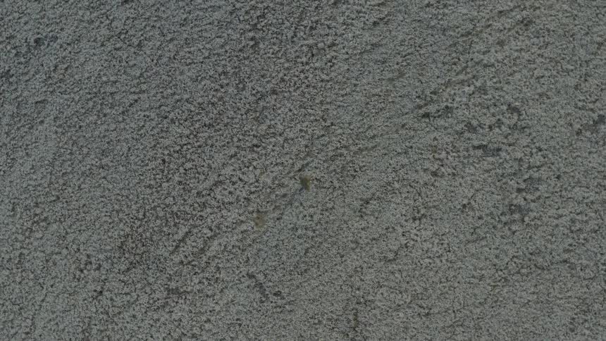 Person walks across sandy ground during the daytime