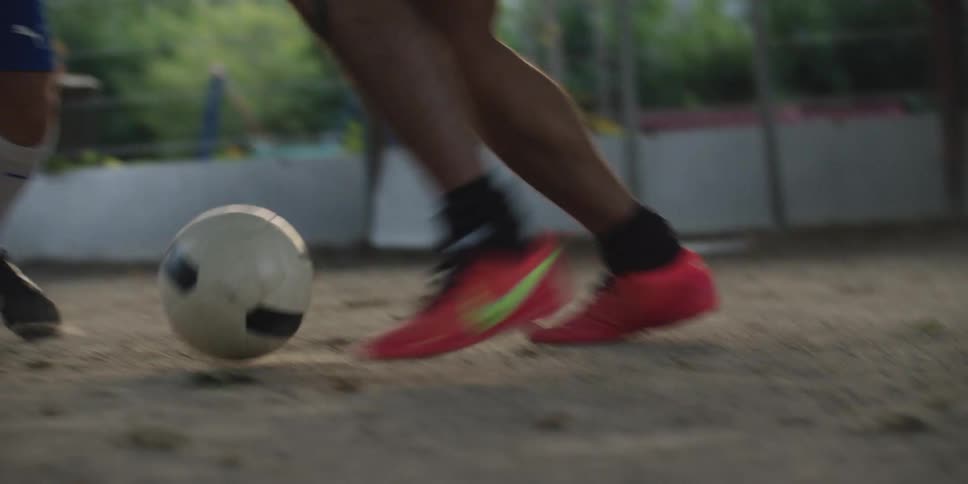 A person dribbles a soccer ball around multiple defenders