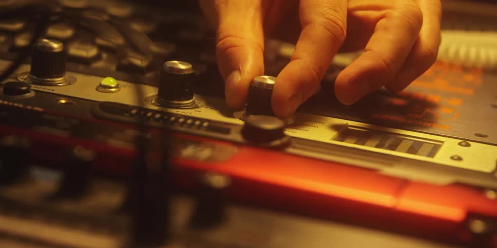 Man adjusts a knob on the control panel of a piece of equipment