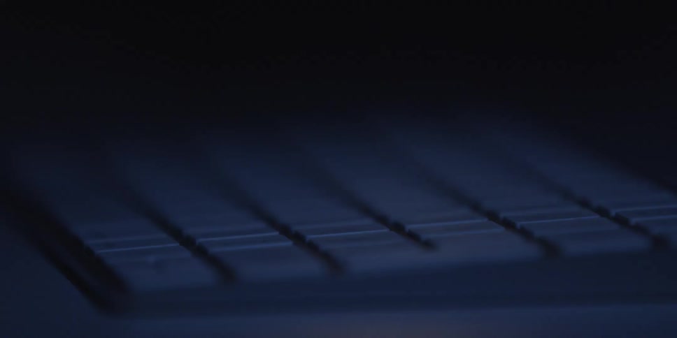 Electronic device keys in closeup with soft blue lighting