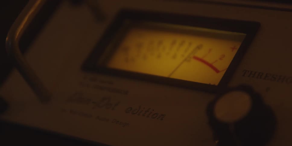 Analog vu meter shows high signal level on vca compressor lit by yellow light