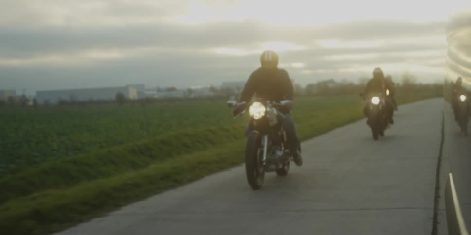 Group of people riding motorcycles on a concrete road