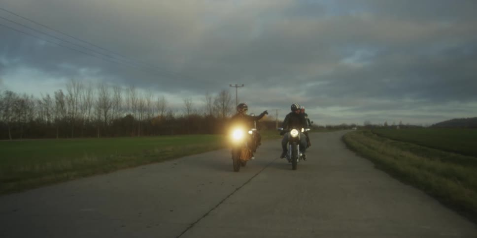 The people ride motorcycles together down the road