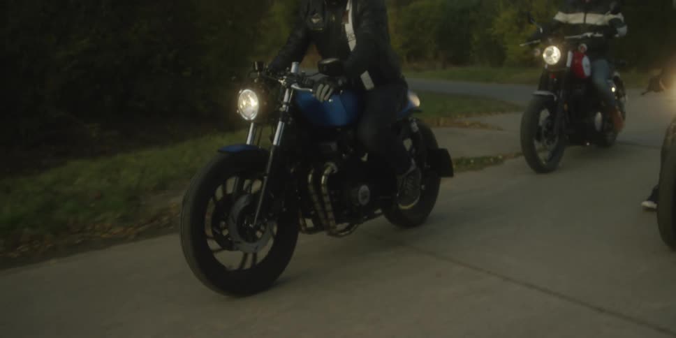 Group of people riding motorcycles on a concrete road