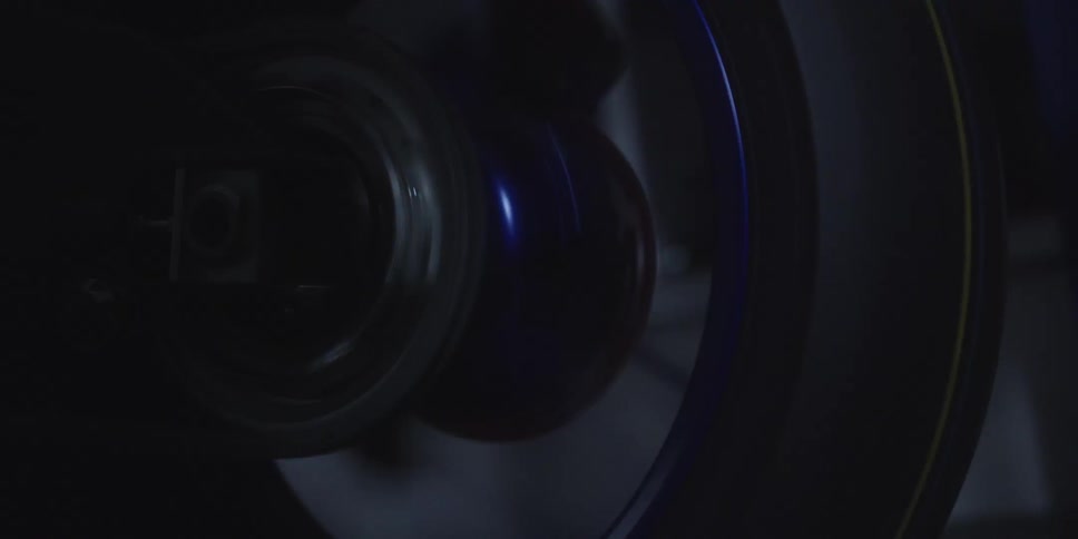 The video shows a closeup dark view of a machine component likely a wheel or pulley rotating rapidly the object has blue and subtle yellow accents and its movement suggests it is part of an industrial or mechanical process