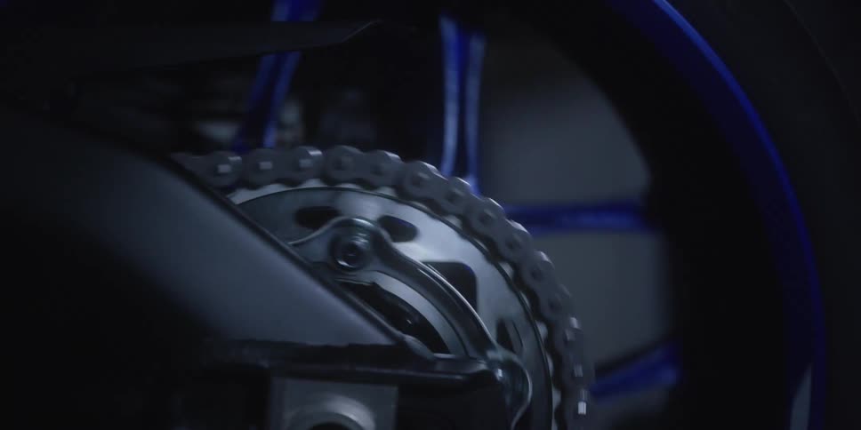 The spinning chain and sprocket of a motorcycles rear wheel