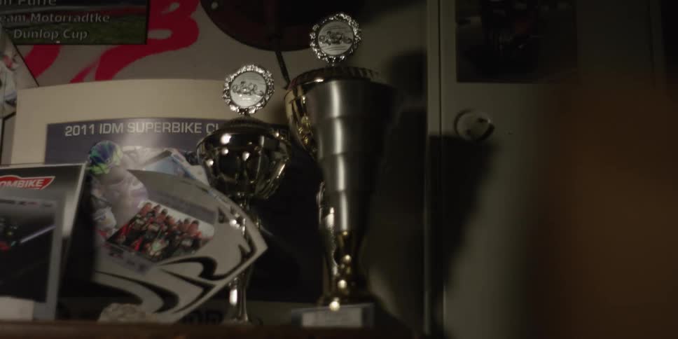 Trophies standing on top of furniture on a room with lights flickering indoors