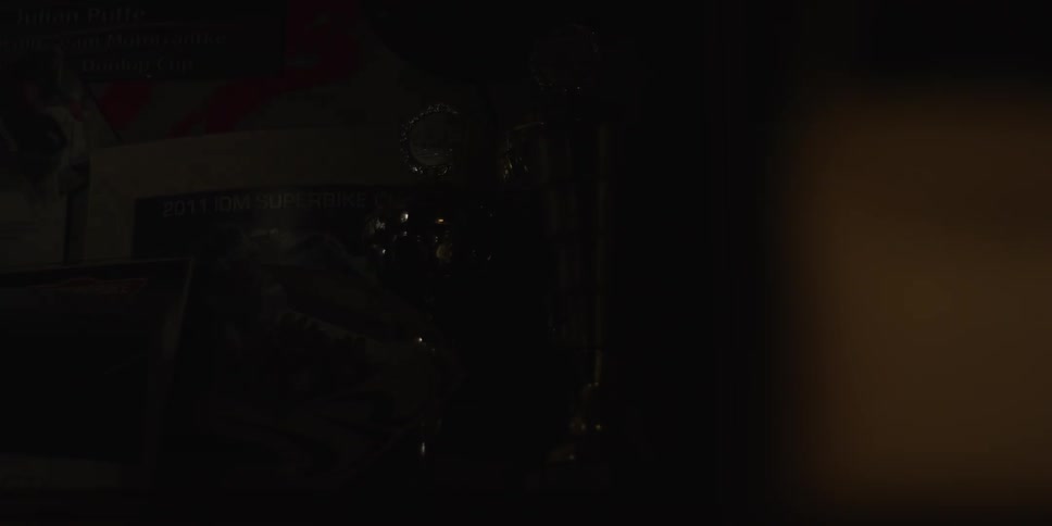 Light briefly illuminates a shelf filled with sports trophies and keepsakes