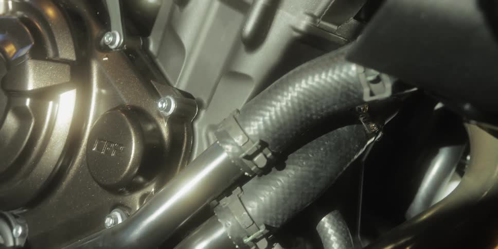 A detailed macrostyle tracking shot glides over the intricate components of a modern motorcycle engine highlighting its metallic surfaces and complex mechanics