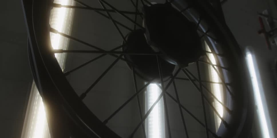 Wheelchair wheel in front of vertical light tubes in highcontrast setting
