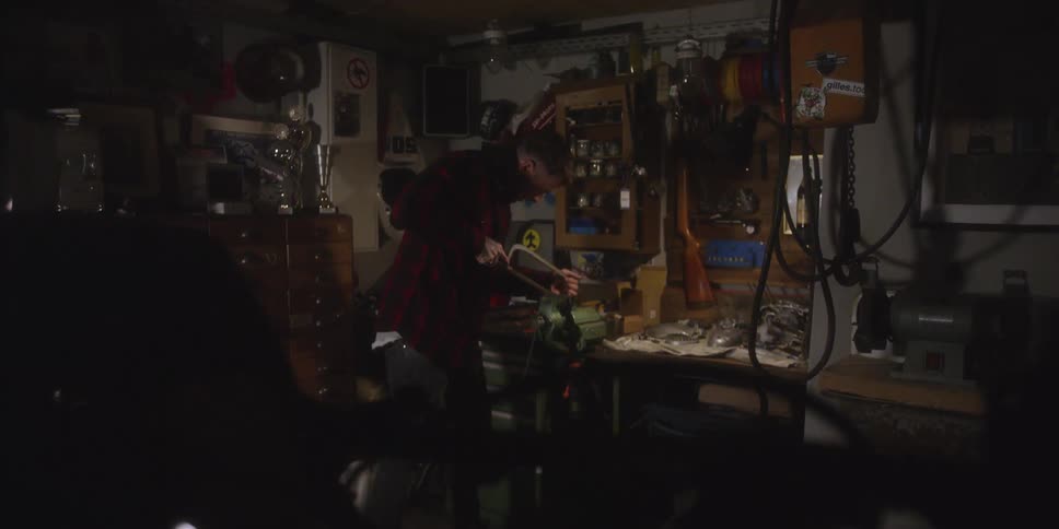 Person in a workshop working with a tool on a lit workbench