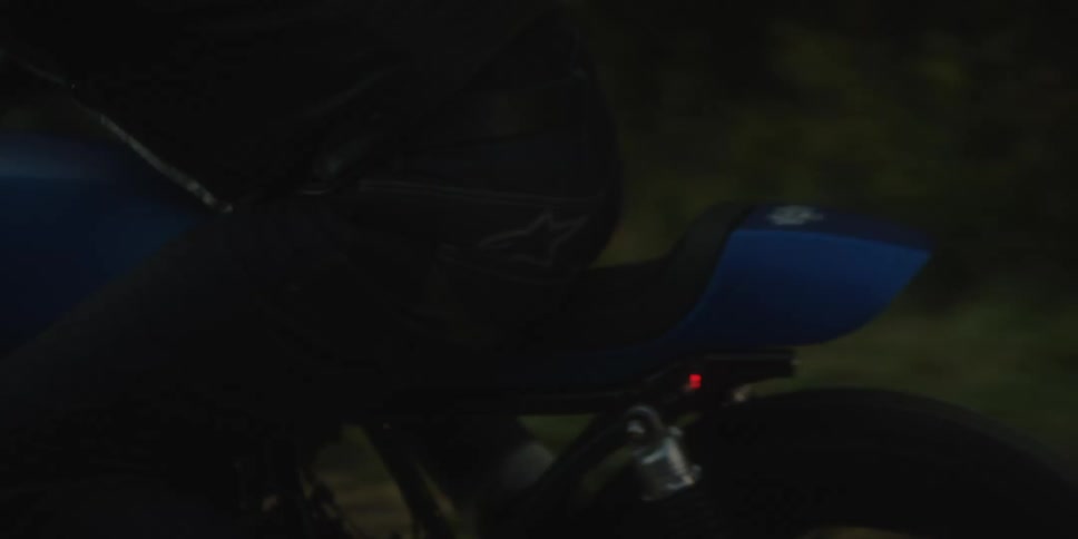 Group of people riding motorcycles on a road by the woods