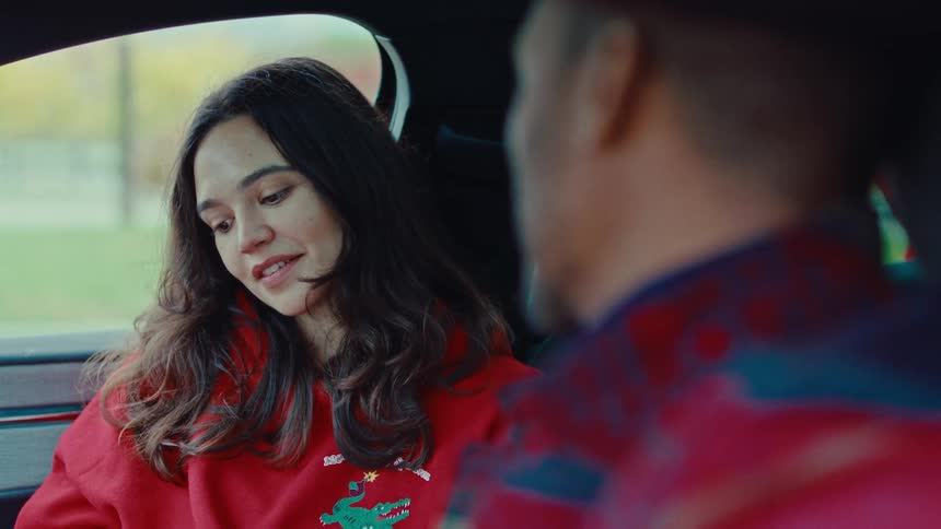 A man and woman talking while sitting in a car