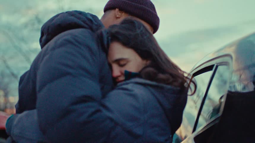 A man and woman hugging each other outdoors