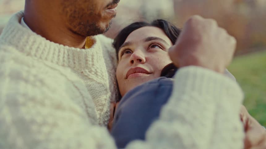 A man and woman cuddling outdoors