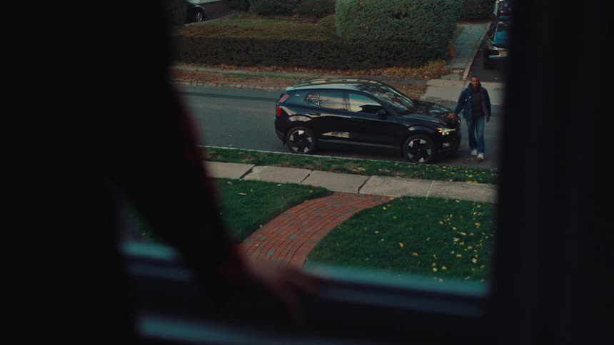 Man walks away from his vehicle toward the house as the person waiting moves away from the window