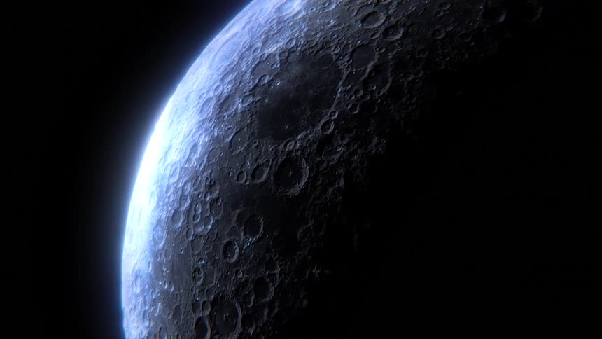 Sunlight highlights the edge of the lunar surface as the moon rotates against the darkness of space