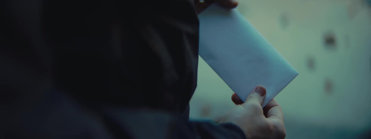 Closeup of a person holding a envelope against a white background