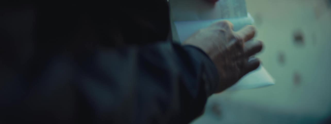 A person opens a white envelope and unfolds the letter inside