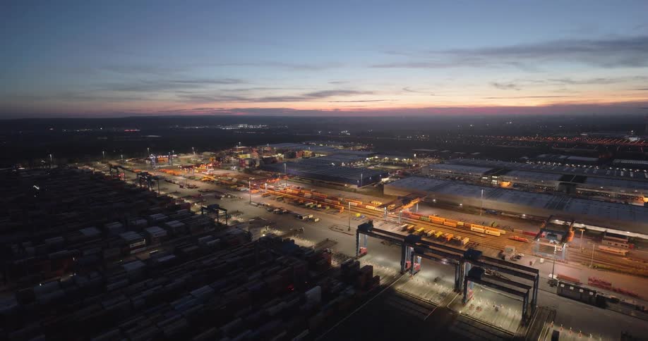 Aerial of a shipping port and container depot in a metropolitan city at sunset