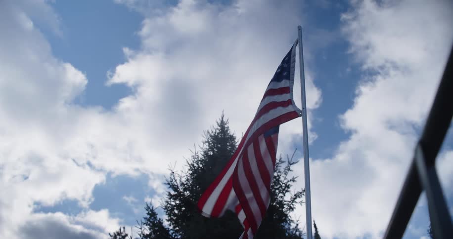 Close up of a flowing american flag on a pole outdoors during daytime