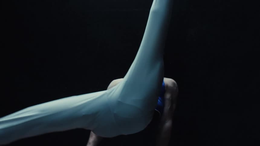 Male gymnast in blue and white uniform performs complex move