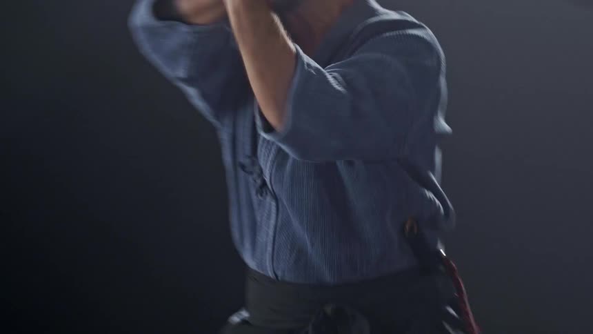 The man is swinging a sword back and forth